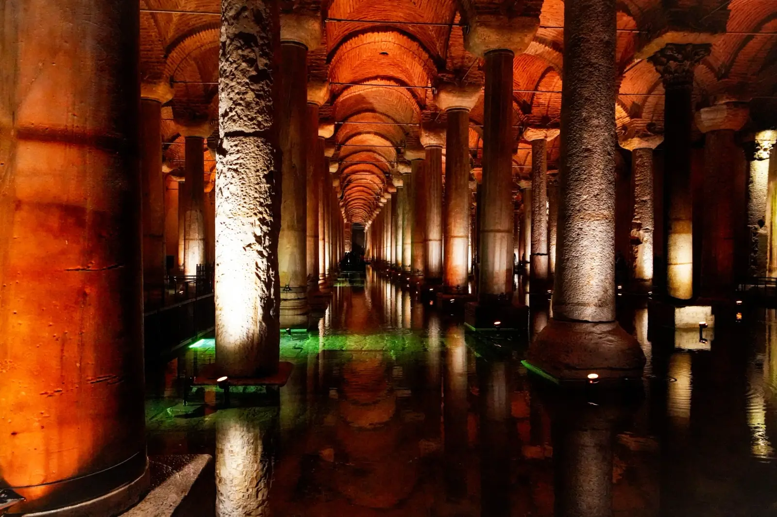 Columnas iluminadas de la Cisterna Basílica reflejadas en el agua